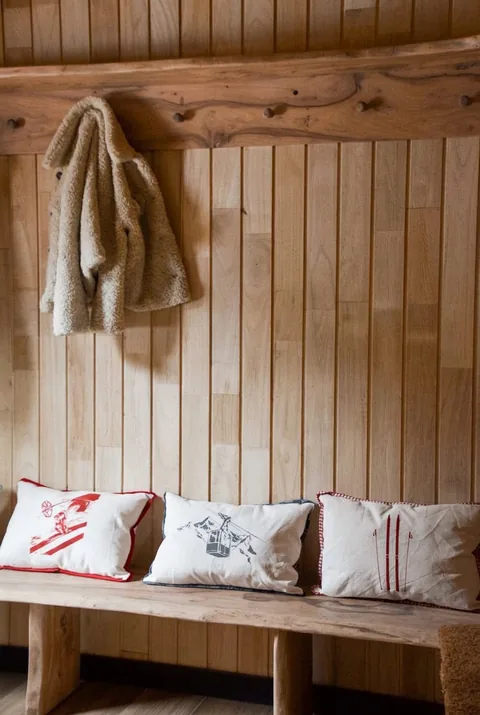 Recibidor: banca rústica de madera y almohadones de esquí