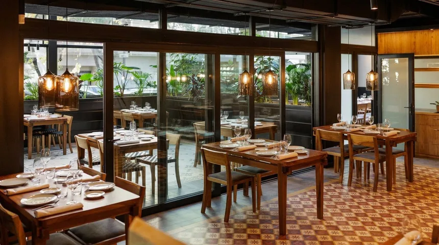 Salón con mesas de madera y lámparas de vidrio ámbar