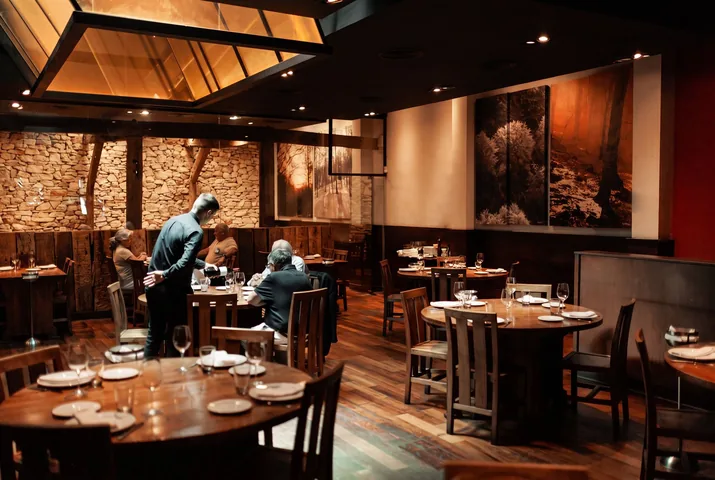 Salón en servicio, con mesas de madera y lucernario