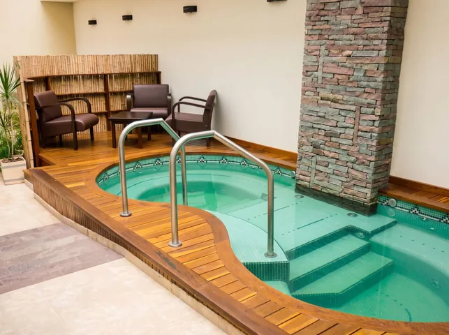 Jacuzzi con deck curvo de madera y columna de piedra