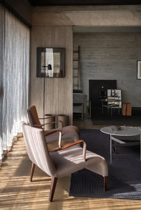 Sillones junto a las cortinas y luz del sol sobre el piso de madera