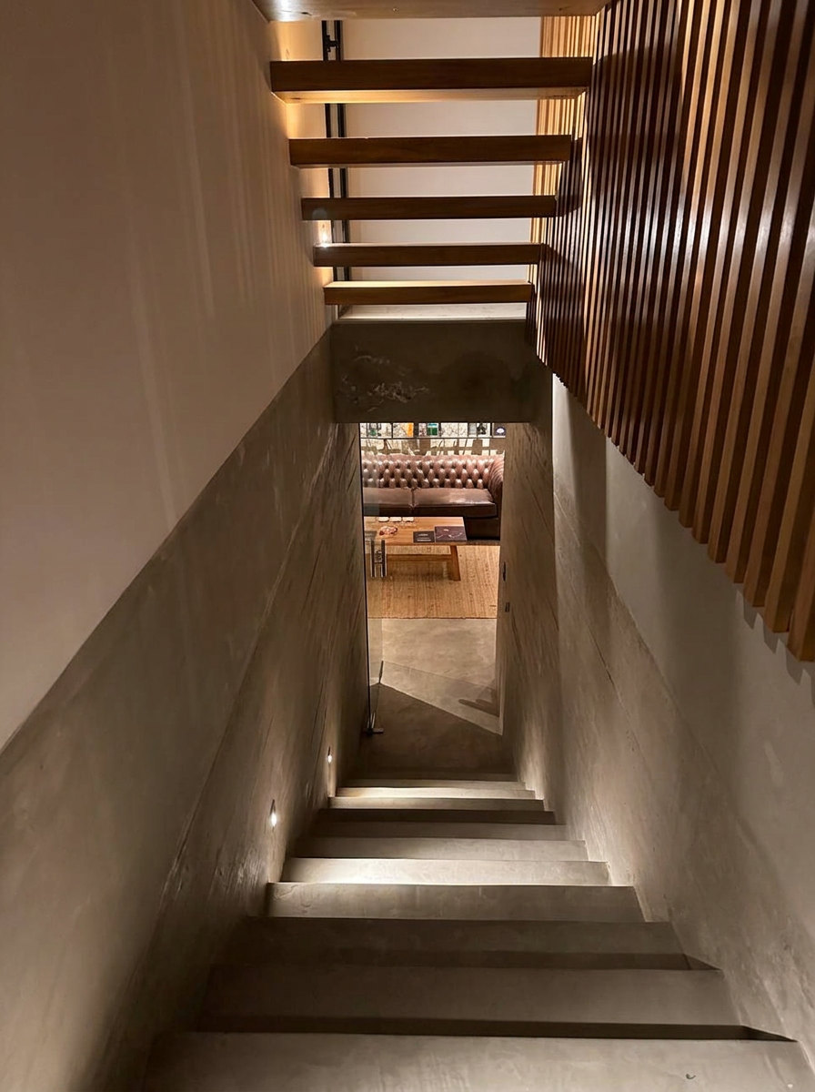 Escalera hacia el subsuelo, con iluminación integrada y celosías