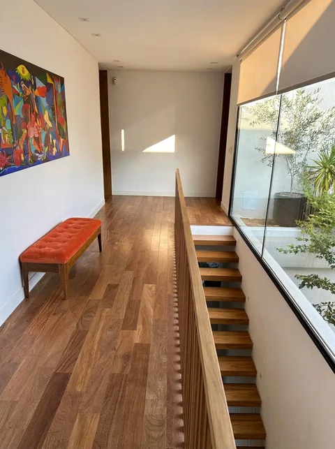 Planta alta con escalera de madera y vista al patio