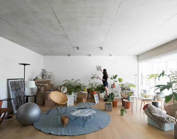 Living con plantas, piso de madera y cielorraso de hormigón