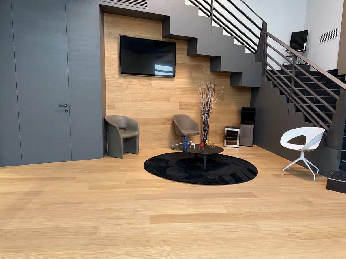 Oficina con piso de roble claro, escalera gris y muro de madera
